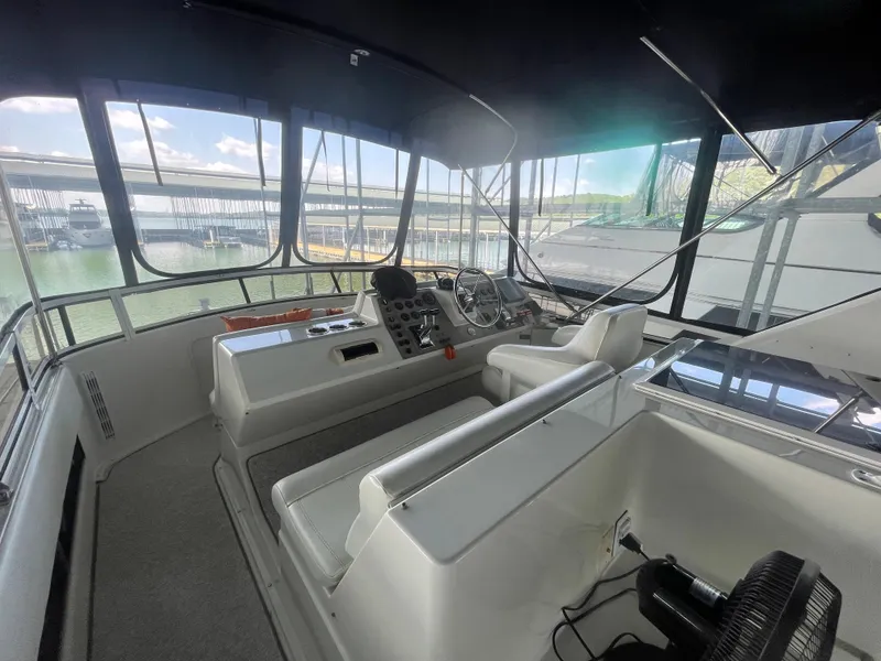 Slide: The Image of 1998 Carver 405 Aft Cabin yacht interior with helm, steering wheel, and panoramic windows. - 8