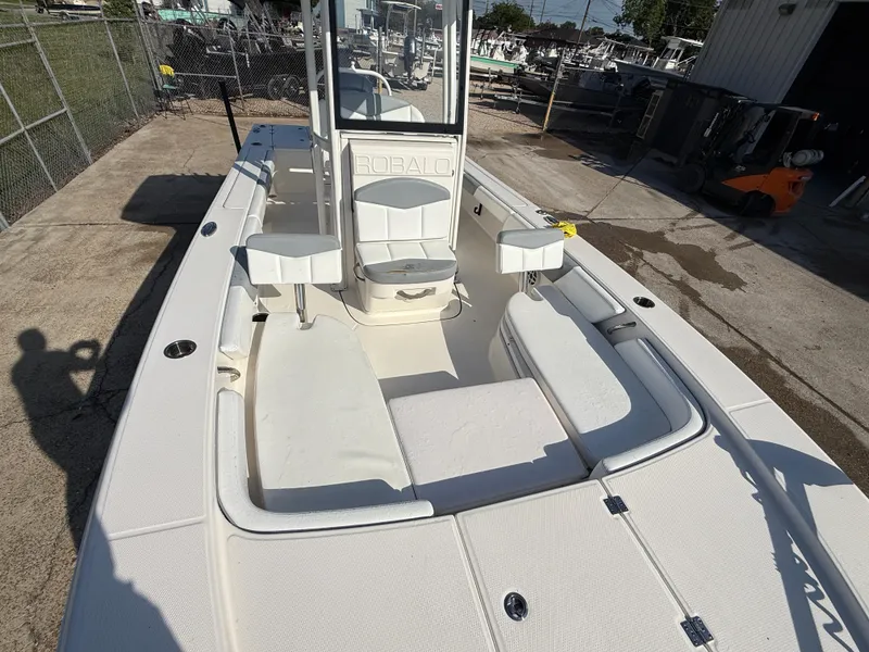 Slide: The Image of 2021 Robalo 246 Cayman boat, spacious deck, white seating, docked outdoors. - 15