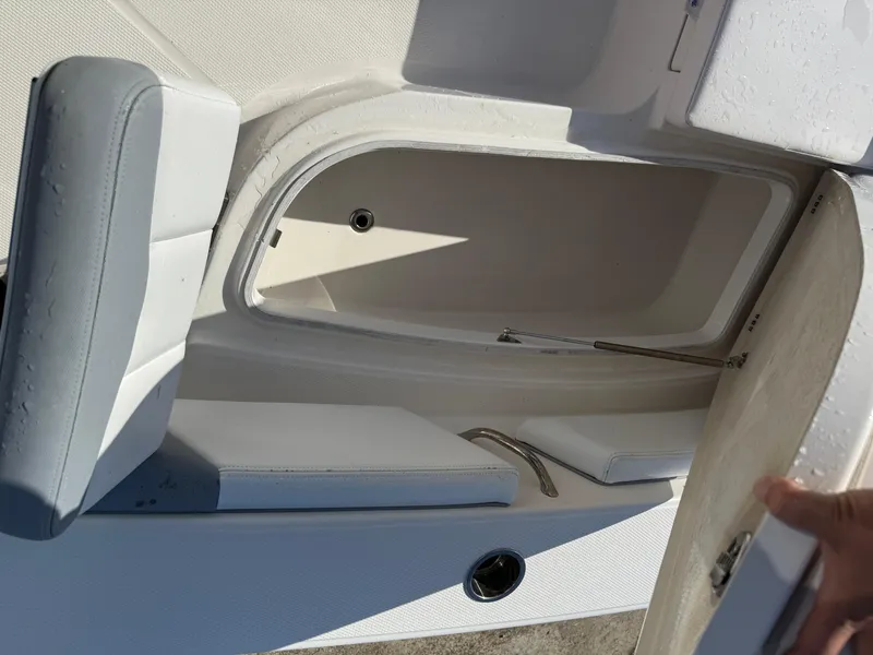 Slide: The Image of 2021 Robalo 246 Cayman boat storage compartment with open lid and seating area. - 16