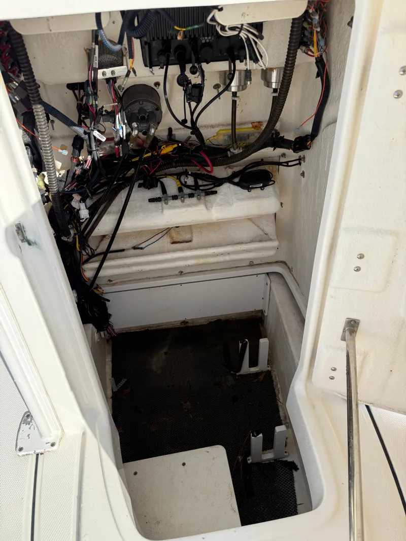 Slide: The Image of 2021 Robalo 246 Cayman boat interior wiring and storage compartment. - 19