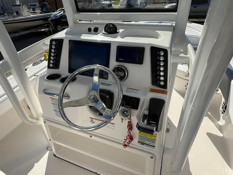 Slide: The Image of 2021 Robalo 246 Cayman boat console with steering wheel and navigation controls. - 20