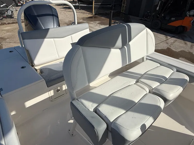 Slide: The Image of 2021 Robalo 246 Cayman boat interior with cushioned seating and engine view. - 21