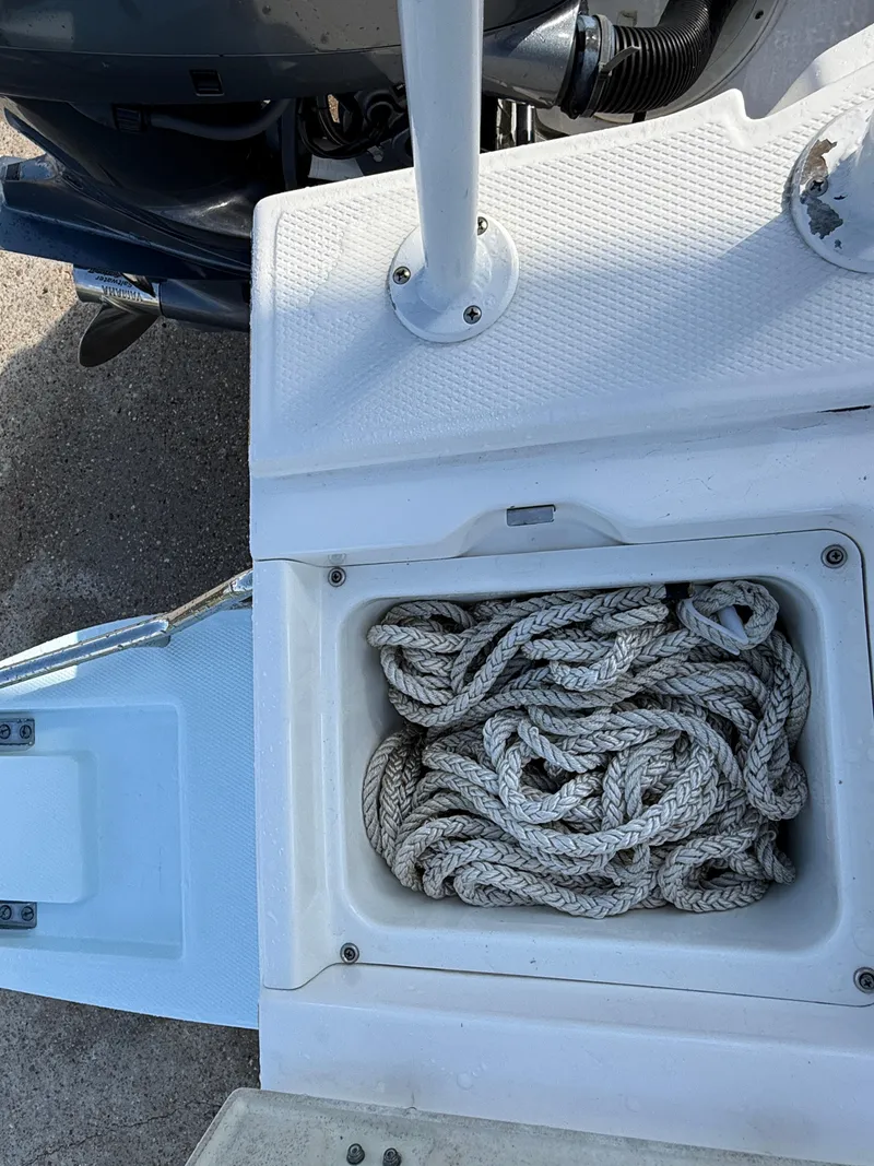 Slide: The Image of Robalo 246 Cayman 2021 boat with rope storage compartment, open lid. - 26