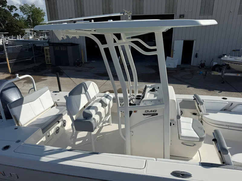 Slide: The Image of 2021 Robalo 246 Cayman boat with T-top and seating, docked near a warehouse. - 8