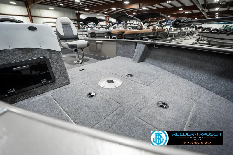 Slide: The Image of 2001 Lund 1775 Pro V SE boat interior with gray carpet and seating in showroom. - 20