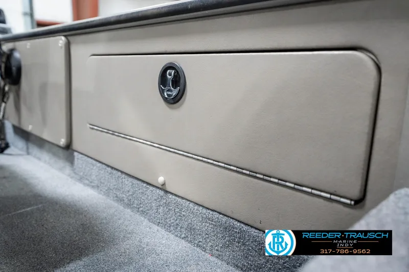 Slide: The Image of 2001 Lund 1775 Pro V SE boat storage compartment, beige interior, Reeder-Trausch Marine logo. - 29