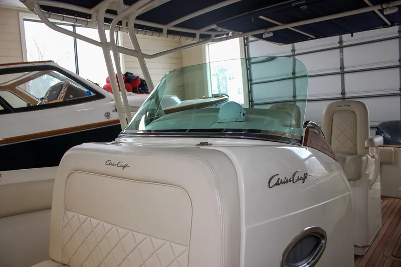 Slide: The Image of 2014 Chris-Craft Catalina 29 Sun Tender boat in a garage, featuring elegant design and seating. - 30