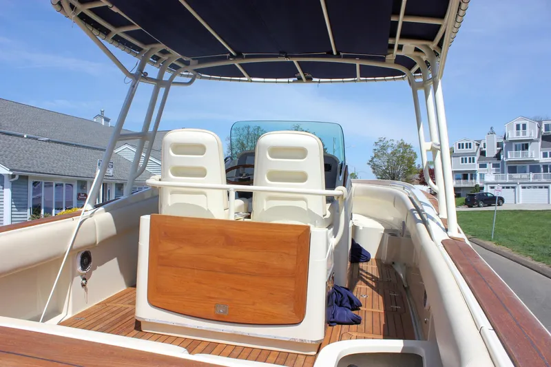 Slide: The Image of 2014 Chris-Craft Catalina 29 Sun Tender with elegant seating and wooden deck, docked near coastal homes. - 38