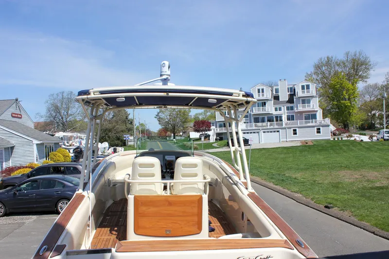 Slide: The Image of 2014 Chris-Craft Catalina 29 Sun Tender boat docked near residential area, showcasing elegant design. - 4