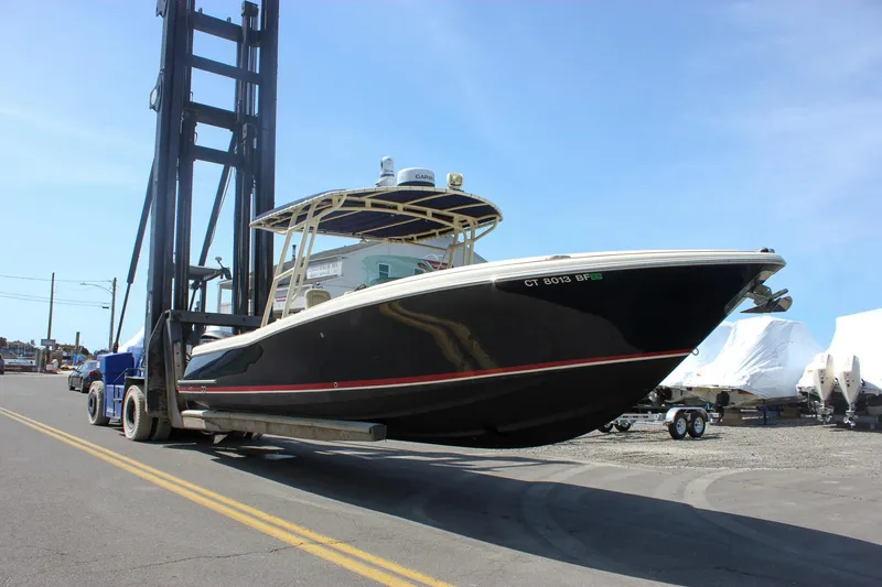 Slide: The Image of 2014 Chris-Craft Catalina 29 Sun Tender on forklift, black hull, marina setting. - 43