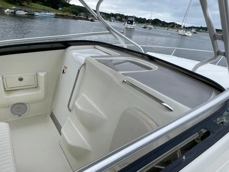 Slide: The Image of 2005 Hydra-Sports 3300 VX boat interior with seating and storage, docked by a scenic waterfront. - 10