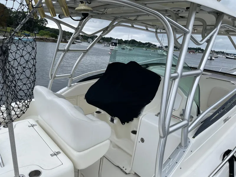 Slide: The Image of 2005 Hydra-Sports 3300 VX boat interior with seating and helm, docked by a scenic waterfront. - 13