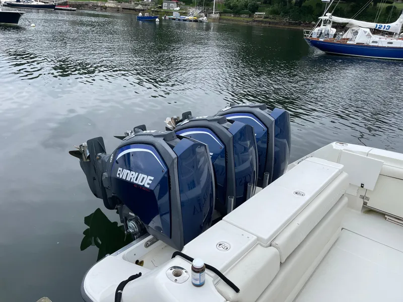 Slide: The Image of 2005 Hydra-Sports 3300 VX boat with Evinrude engines on a calm lake. - 14