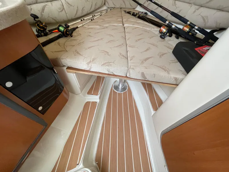 Slide: The Image of 2005 Hydra-Sports 3300 VX cabin interior with fishing rods and cushioned seating. - 28