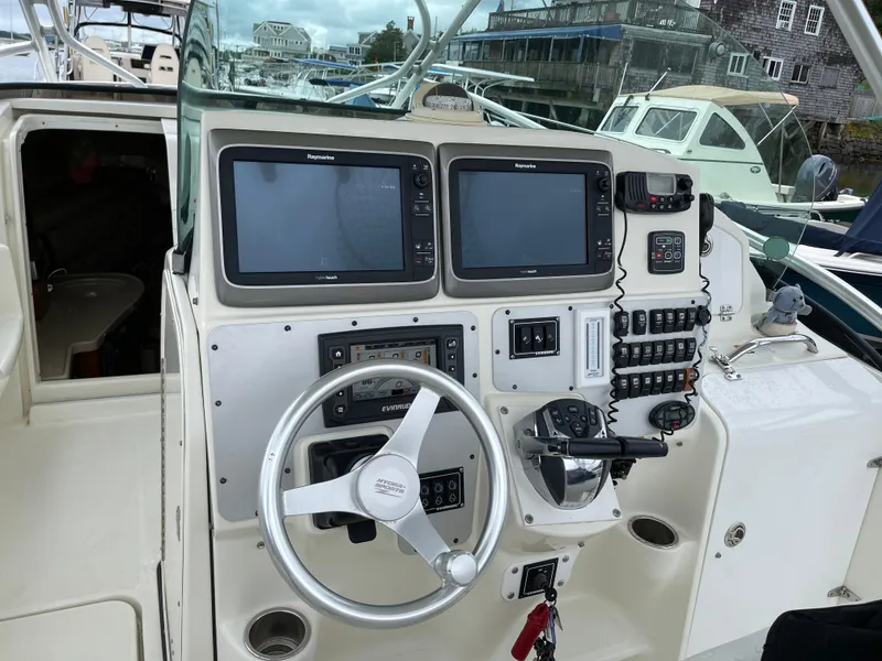 Slide: The Image of 2005 Hydra-Sports 3300 VX boat dashboard with steering wheel and navigation screens. - 5