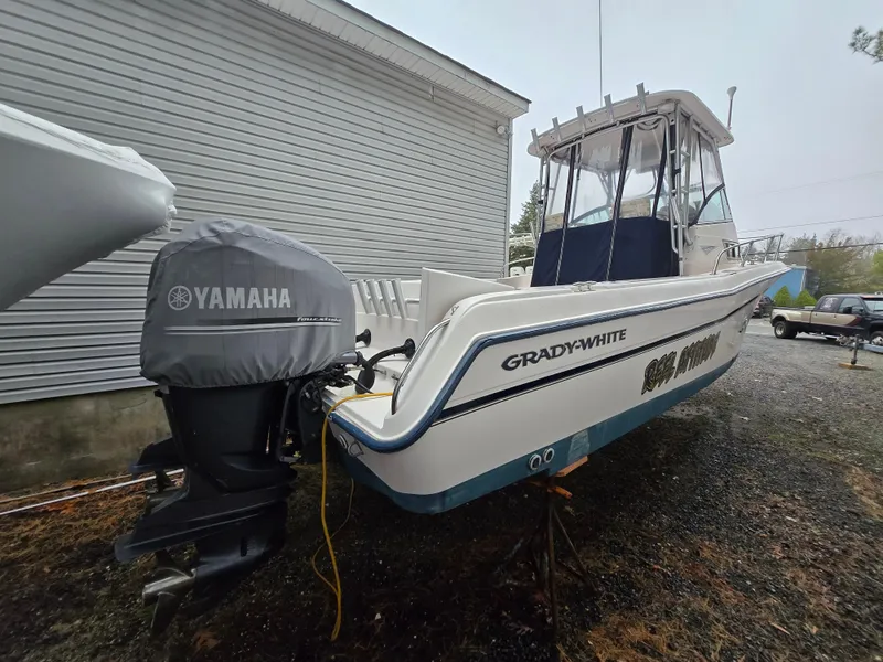 Slide: The Image of 1997 Grady-White 272 Sailfish boat with Yamaha outboard motor, parked on gravel. - 1