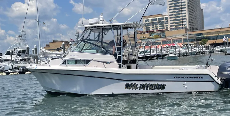 Slide: The Image of 1997 Grady-White 272 Sailfish boat named "Reel Attitude" docked in a marina. - 2