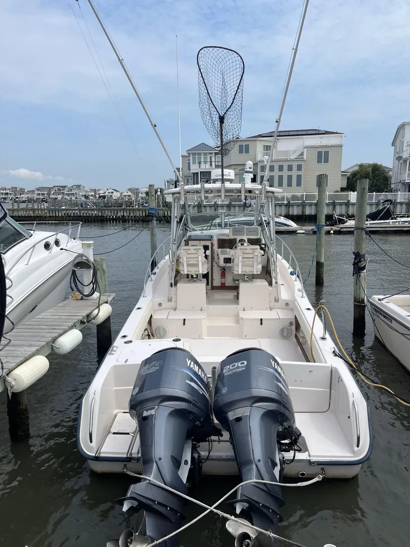 Slide: The Image of 1997 Grady-White 272 Sailfish boat docked with twin Yamaha engines, fishing net visible. - 6