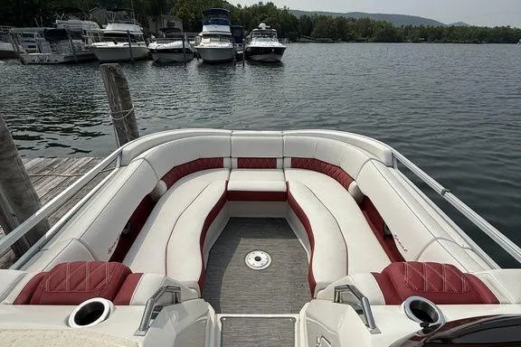 Slide: The Image of 2021 Bennington 24 RTSB pontoon boat with red and white seating at a lakeside dock. - 12