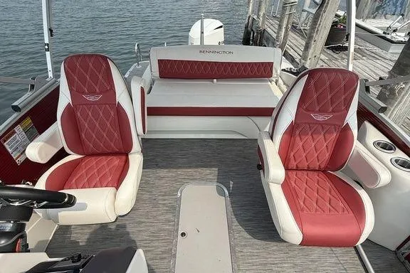 Slide: The Image of 2021 Bennington 24 RTSB boat interior with red and white seating, docked by the water. - 15