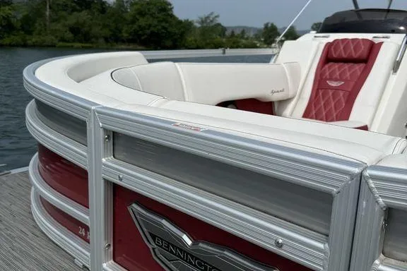 Slide: The Image of 2021 Bennington 24 RTSB pontoon boat with red and white seating, docked by a lake. - 19