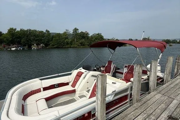Slide: The Image of 2021 Bennington 24 RTSB pontoon boat docked on a serene lake. - 2