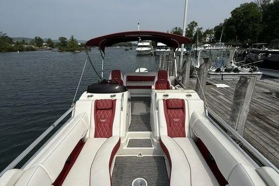 Slide: The Image of 2021 Bennington 24 RTSB pontoon boat with red and white seating, docked by a lake. - 22
