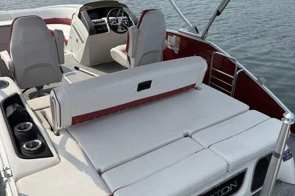 Slide: The Image of 2021 Bennington 24 RTSB pontoon boat interior with white seating and red accents on the water. - 7