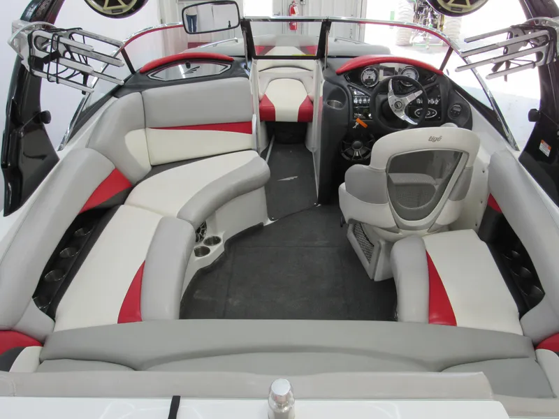 Slide: The Image of 2009 Tigé 22 EV boat interior with red and gray seating, steering wheel, and dashboard. - 3