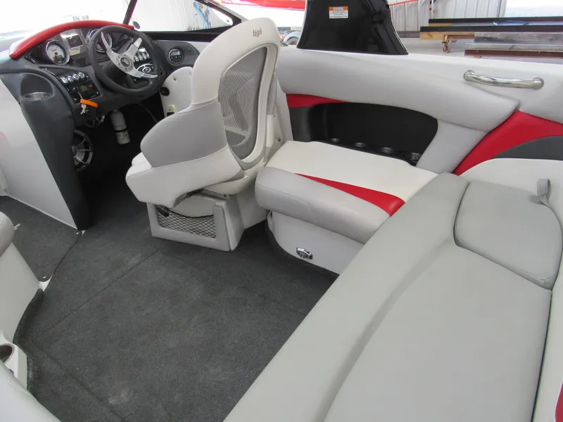 Slide: The Image of 2009 Tigé 22 EV boat interior with gray and red seating, steering wheel, and dashboard. - 5