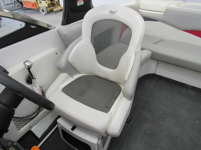 Slide: The Image of Captain's seat in 2009 Tigé 22 EV boat, featuring white upholstery and mesh backrest. - 9