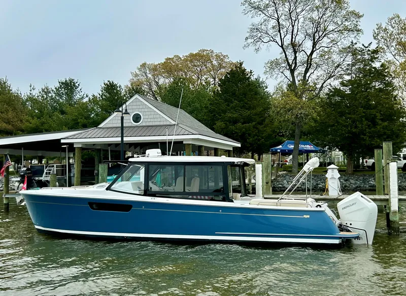 Slide: The Image of 2025 MJM 3 boat docked by a lakeside cabin, surrounded by trees. - 4