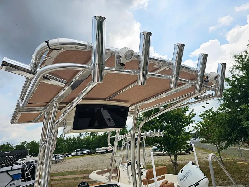 Slide: The Image of 2025 Pioneer 202 Sportfish boat with T-top and rod holders under a cloudy sky. - 12