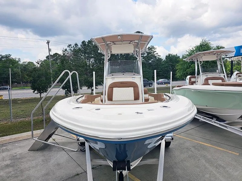 Slide: The Image of 2025 Pioneer 202 Sportfish boat on trailer, front view, outdoors, cloudy sky. - 2