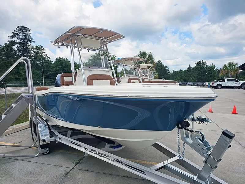 Slide: The Image of 2025 Pioneer 202 Sportfish boat on trailer, blue hull, parked outdoors under cloudy sky. - 3