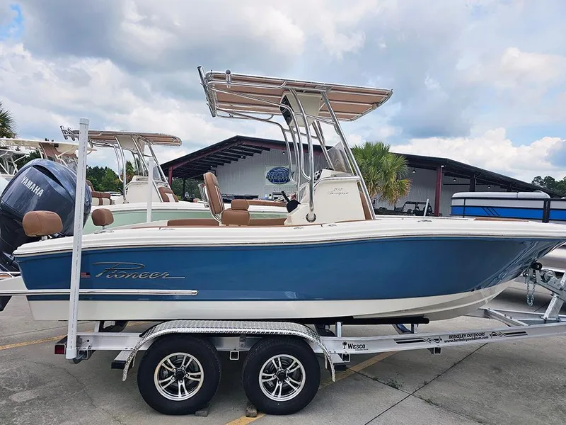 Slide: The Image of 2025 Pioneer 202 Sportfish boat on trailer, blue hull, parked outdoors. - 4