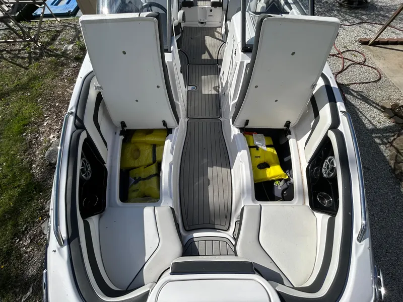 Slide: The Image of 2020 Yamaha Boats 242 Limited S interior with open storage compartments and seating. - 16