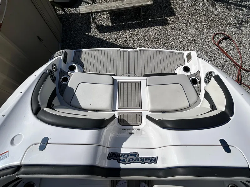 Slide: The Image of 2020 Yamaha Boats 242 Limited S, rear seating area with cup holders and gray upholstery. - 23