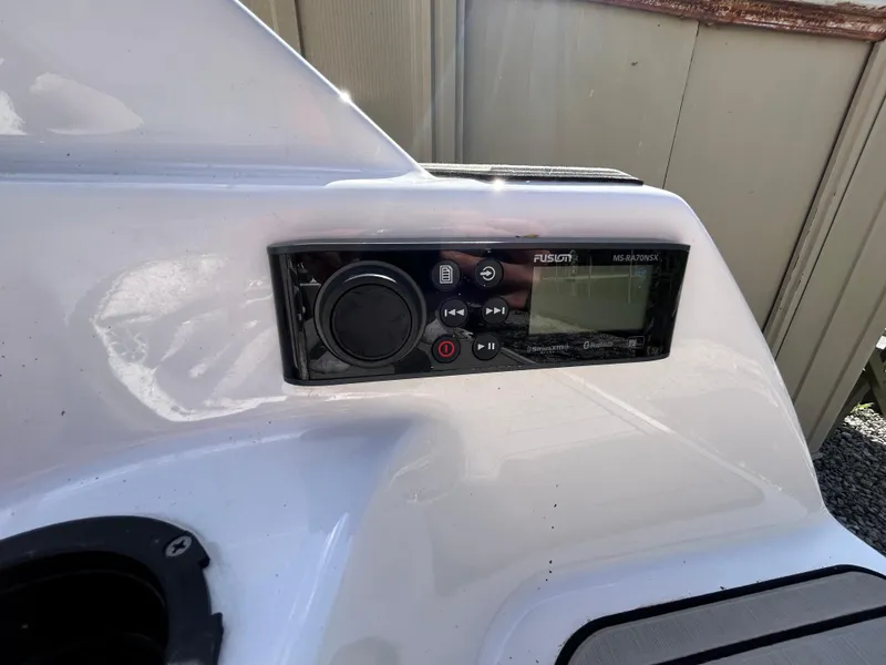 Slide: The Image of 2020 Yamaha Boats 242 Limited S audio control panel on white dashboard. - 24
