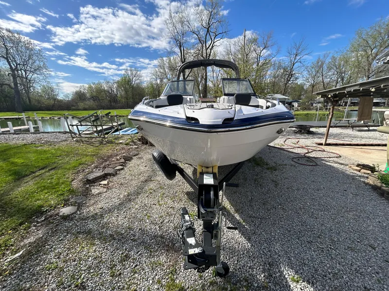 Slide: The Image of 2020 Yamaha Boats 242 Limited S on trailer, parked outdoors on gravel near a lake. - 5