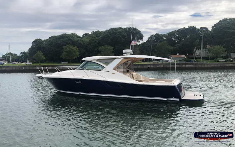 Slide: The Image of 2013 Tiara Yachts 3600 Coronet cruising on a calm waterway with lush greenery. - 0