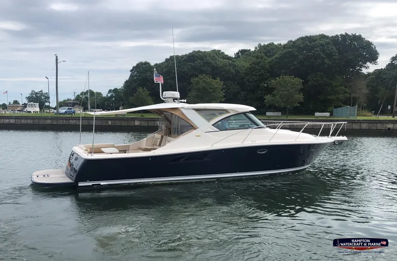 Slide: The Image of 2013 Tiara Yachts 3600 Coronet cruising on a calm waterway with lush greenery. - 1