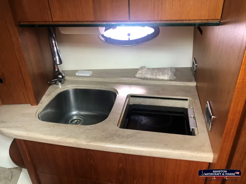 Slide: The Image of 2013 Tiara Yachts 3600 Coronet kitchen with sink and countertop, featuring wood cabinetry. - 18