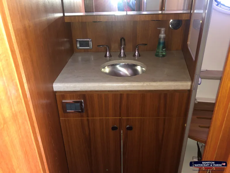 Slide: The Image of 2013 Tiara Yachts 3600 Coronet bathroom with wooden cabinetry and stainless steel sink. - 25