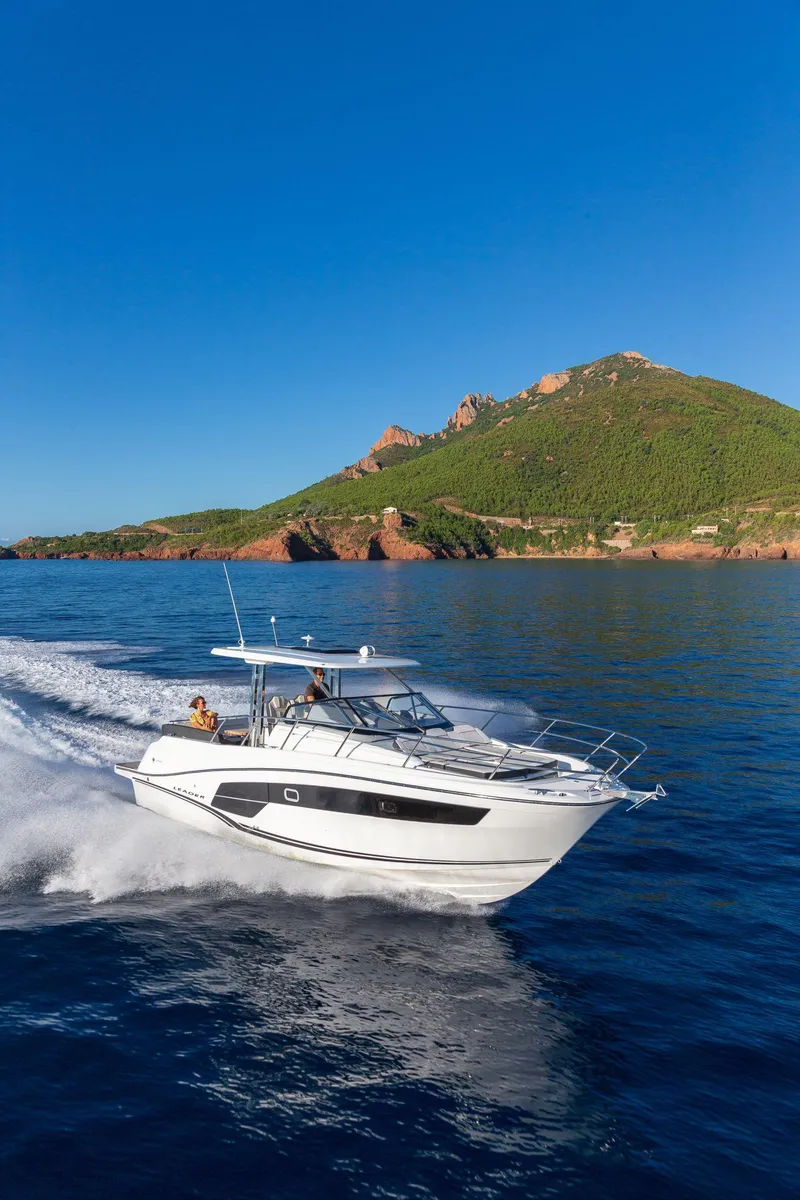 Slide: The Image of 2025 Jeanneau Leader 10.5 WA Series 2 cruising on blue ocean near scenic coastline. - 19