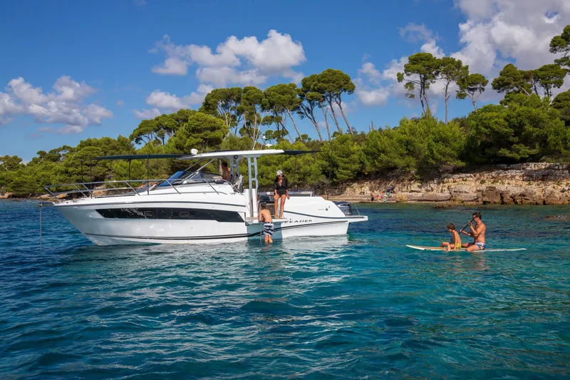 Slide: The Image of 2025 Jeanneau Leader 10.5 WA Series 2 boat in scenic coastal waters with people enjoying water activities. - 17