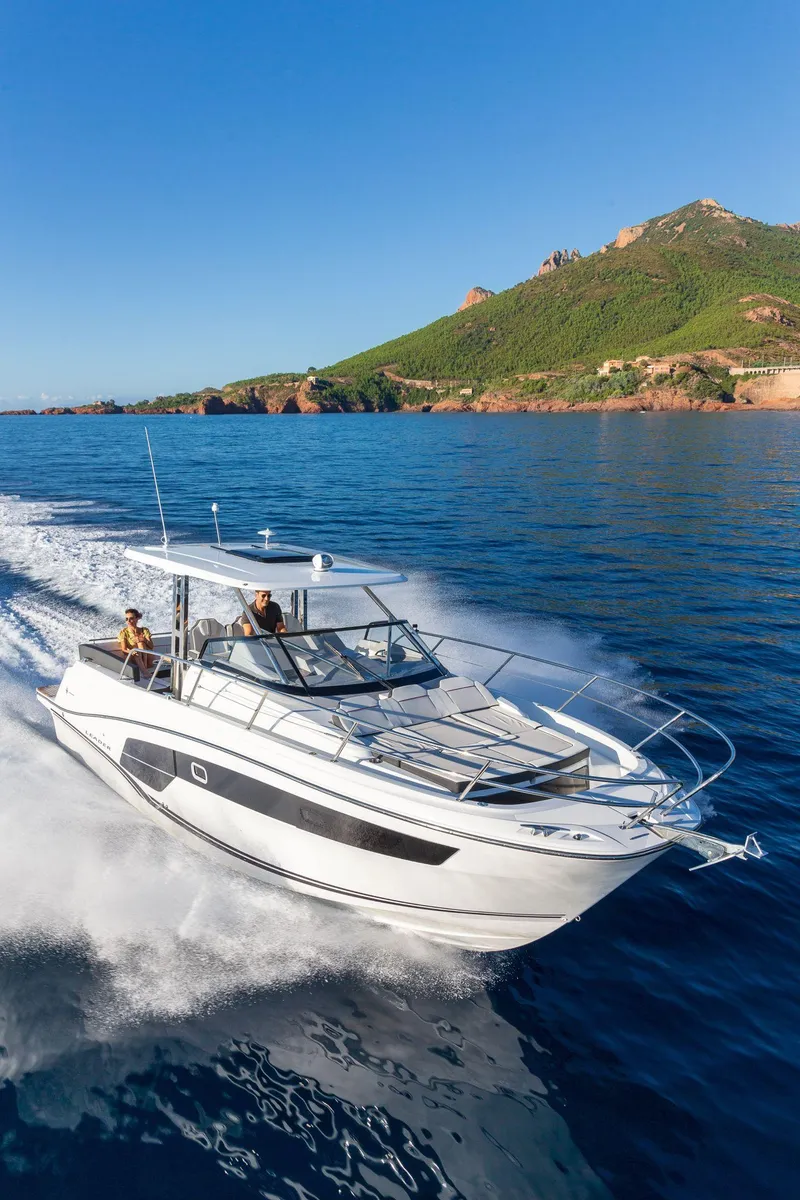 Slide: The Image of 2025 Jeanneau Leader 10.5 WA Series 2 cruising on blue ocean near scenic coastline. - 20