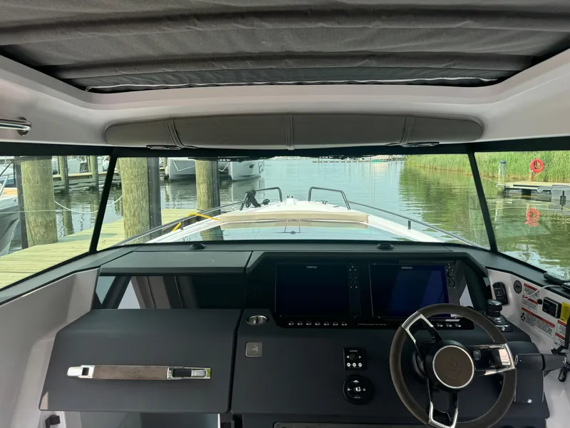 Slide: The Image of 2024 Axopar 37 Cross Cabin XC interior with steering wheel and dashboard view. - 13