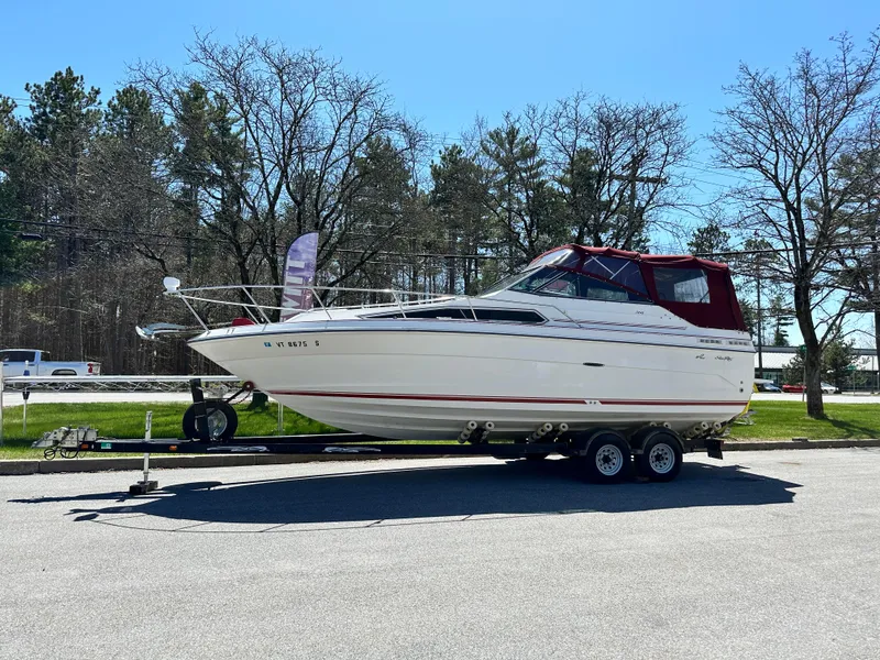 Slide: The Image of 1989 Sea Ray 268 Sun Dancer boat on trailer, parked outdoors, clear sky. - 0