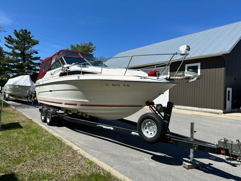 Slide: The Image of 1989 Sea Ray 268 Sun Dancer boat on trailer, parked outdoors near a building. - 1